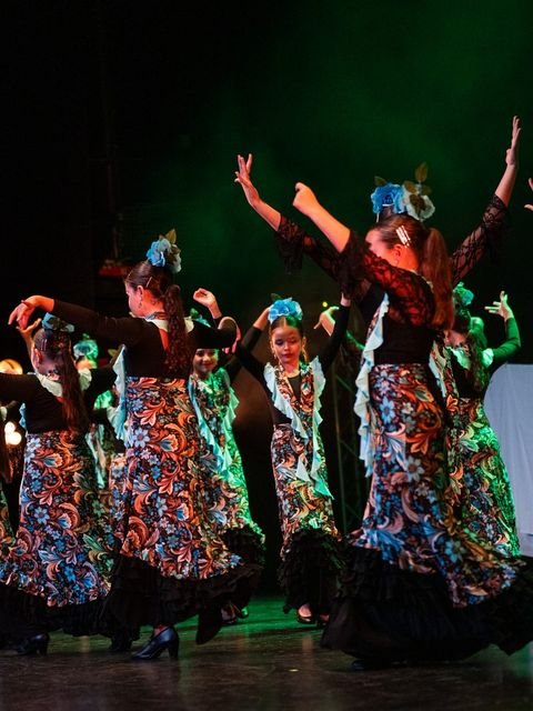 Grupo de alumnas con los brazos en alto durante una coreografía de flamenco